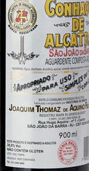 Bottle of São João da Barra Tar Cognac Aperitif by Joaquim Thomaz de Aquino Filho, 900ml, with a clear label and dark glass bottle.